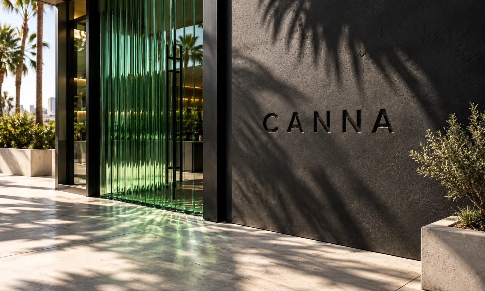 Modern CANNA California studio entrance with green glass and palm shadows